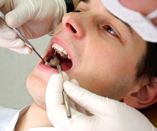 A dentist uses a concave mirror to view a patient's teeth.