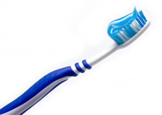 A toothbrush with toothpaste on it containing sodium lauryl sulfate.